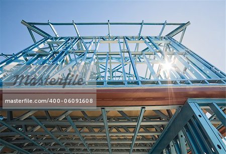 New home under construction using steel frames against a sunny sky.