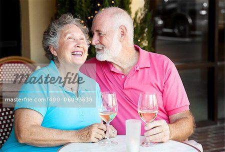 Senior couple at a cafe, enjoying wine and conversation together.