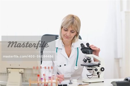 Middle age doctor woman working with microscope