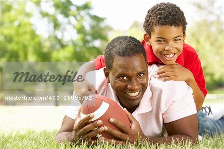 Father And Son In Park With American Football