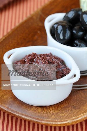 appetizer of olives, tapenade on a wooden board
