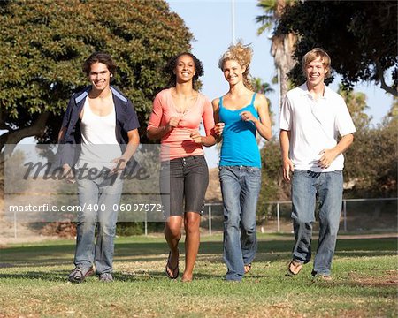 Group Of Teenagers Running In Park