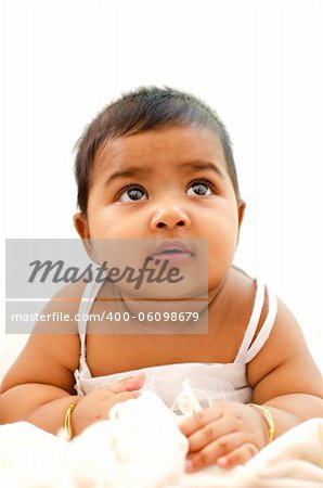 6 months old Indian baby girl having thought, looking up