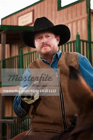 Tough old west cowboy on horseback with shotgun