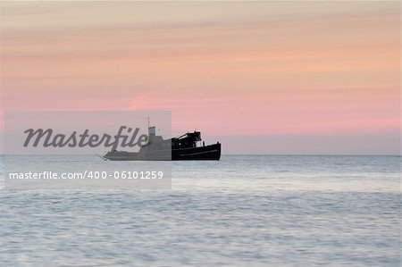 A lone boat at sea before sunrise