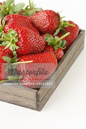Fresh red strawberries in a wooden box on a white.