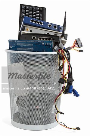 electronic scrap in trash can. keyboard, power supply, router, cables, logicboard, hard drive, switch