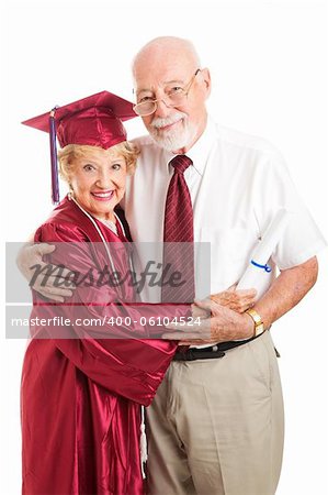 Senior woman graduating from college, standing with her proud, supporting husband.  Isolated on white.