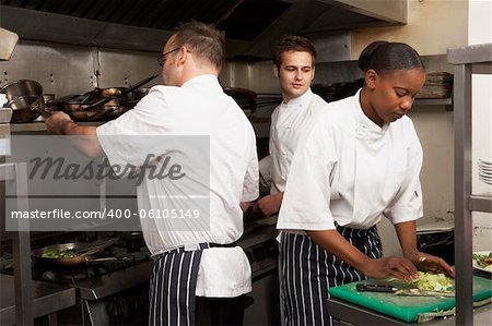 Team Of Chefs Preparing Food In Restaurant Kitchen