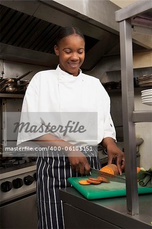Female Chef Preparing Vegetables In Restaurant Kitchen