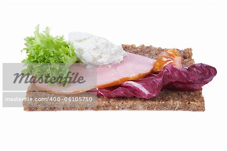 whole grain rye bread sandwich with ham and vegetables isolated on white