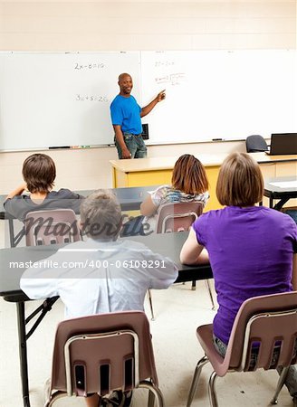 Handsome african-american math teacher solving a problem for his class.