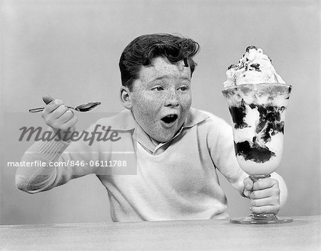 ANNÉES 1950 FRECKLE FACE GARÇON CREUSER DANS GIANT ICE CREAM SUNDAE