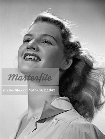 1940s SMILING PORTRAIT YOUNG BLONDE WOMAN WITH HEAD TILTED BACK WIND BLOWING THROUGH HAIR