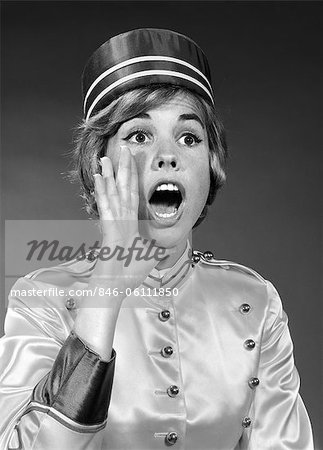 1960s WOMAN IN BELL HOP OUTFIT YELLING AN ANNOUNCEMENT