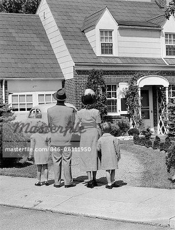 1940s FAMILY MOTHER FATHER DAUGHTER SON LOOKING AT SUBURBAN HOUSE BACK VIEW OUTDOOR