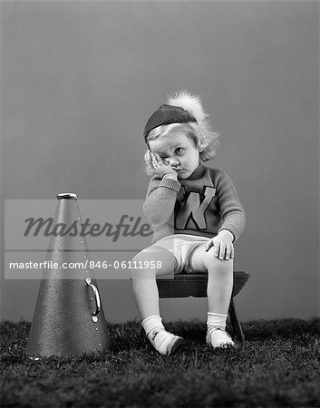 1940s UNHAPPY LITTLE GIRL CHEERLEADER WEARING A CAP AND VARSITY SWEATER FRUSTRATED SAD LOOK
