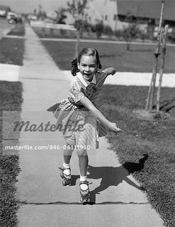 1950s LITTLE GIRL ROLLER-SKATING ON SIDEWALK