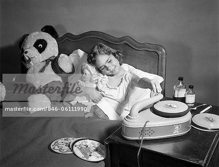 1950s SICK LITTLE GIRL IN BED PLAYING WITH RECORD PLAYER 1950s SICK LITTLE GIRL IN BED PLAYING WITH RECORD PLAYER