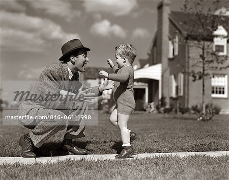 1940s FATHER GREETING SON RUNNING TOWARDS HIM ON SIDEWALK