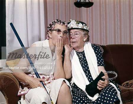 1960s TWO SENIOR OLDER WOMEN SITTING ON SOFA GOSSIPING