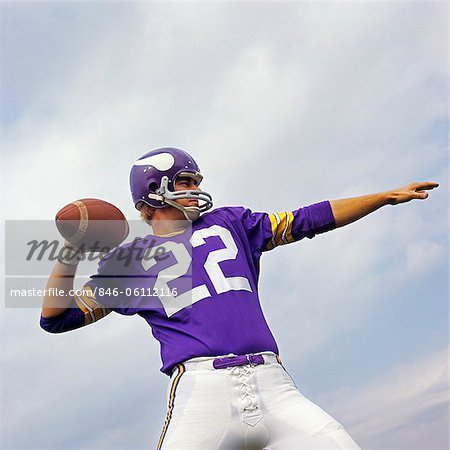 1970s AMERICAN FOOTBALL PLAYER PURPLE JERSEY 22 ABOUT TO THROW THE BALL