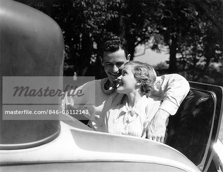 1930s COUPLE IN BACK RUMBLE SEAT REAR OF CAR MAN WITH ARM AROUND WOMAN