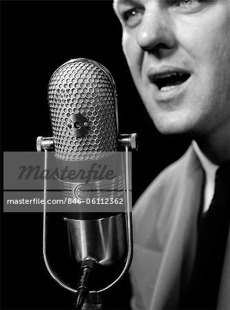 1950s CLOSE-UP OF MAN ANNOUNCER TALKING INTO MICROPHONE NEWSCASTER INDOOR SYMBOLIC FREEDOM OF SPEECH