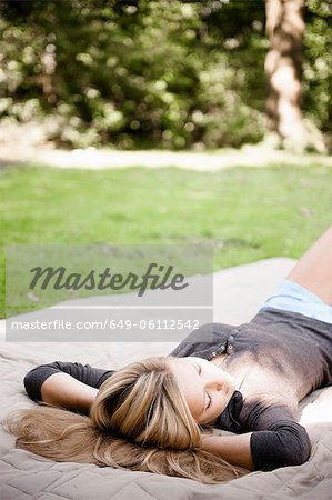 Woman laying on blanket in park