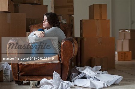 Teenage girl in armchair in new home