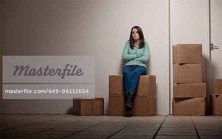 Teenage girl sitting on cardboard box