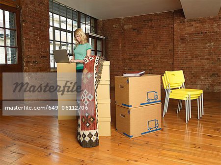 Woman with cardboard boxes in new home