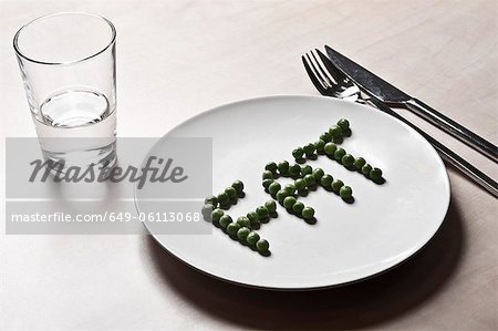 Peas arranged to spell fat on plate