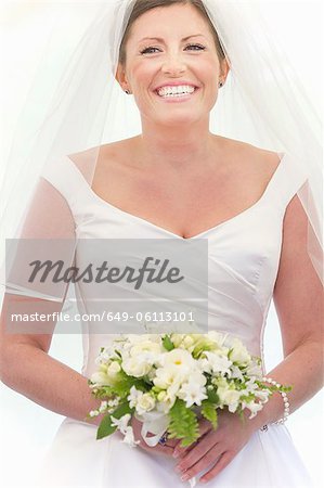 Smiling bride holding bouquet