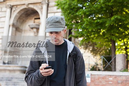 Mann mit Handy auf Stadtstraße
