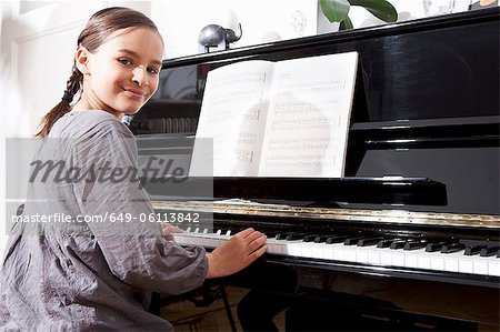 Jeune fille souriante pratiquant au piano