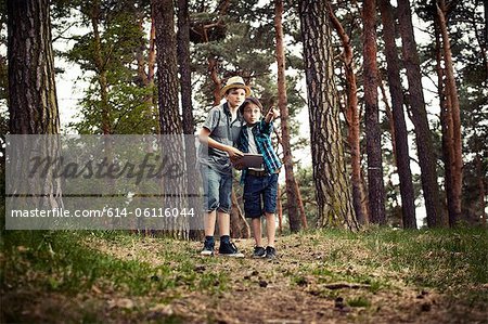 Boys with digital tablet in forest
