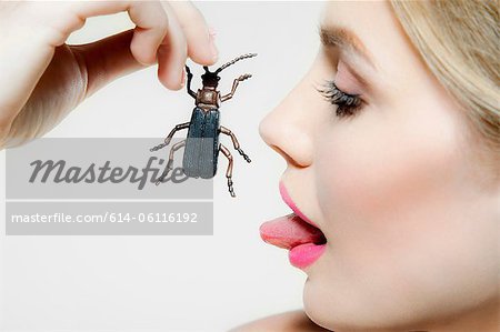 Young woman eating plastic beetle