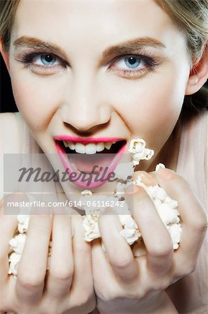 Jeune femme mangeant maïs soufflé
