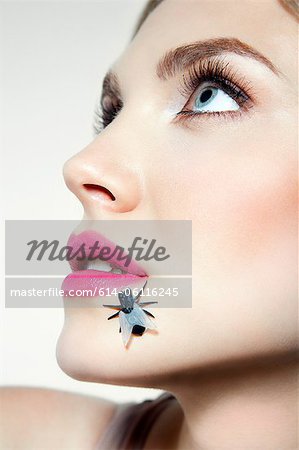 Young woman with plastic fly on face