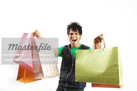 Portrait of a young man posing with shopping bags