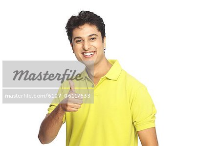 Portrait of young man posing with thumb up