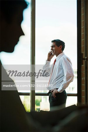 Silhouette der Geschäftsmann mit Handy, durch Fenster