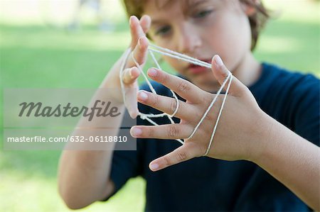 Boy playing cat's cradle, focus on hands