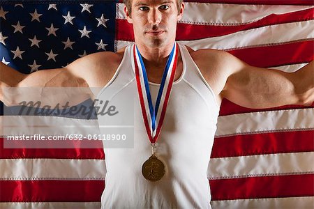 Male medalist in front of American flag