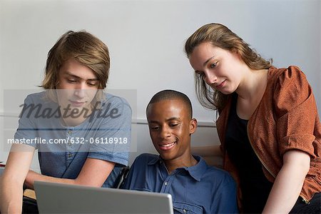 Friends looking at laptop computer together