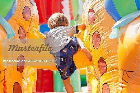 Boy playing in bouncy castle, rear view