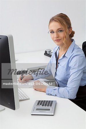 Jeune femme assise au bureau dans le bureau