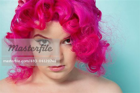Portrait d'une femme cheveux rose sur fond coloré