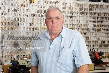 Portrait of a senior male owner of key store
